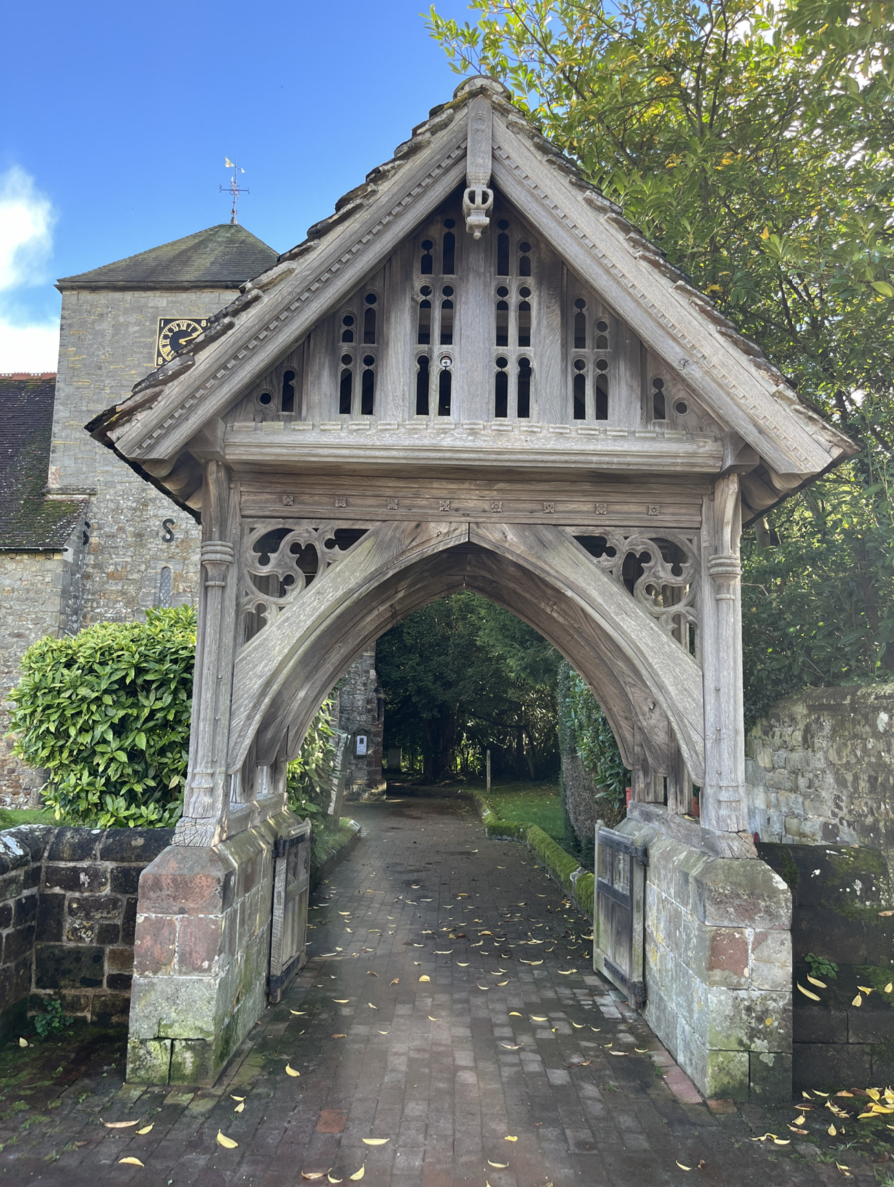 an ornate brick and wood gate leading into a churchyard